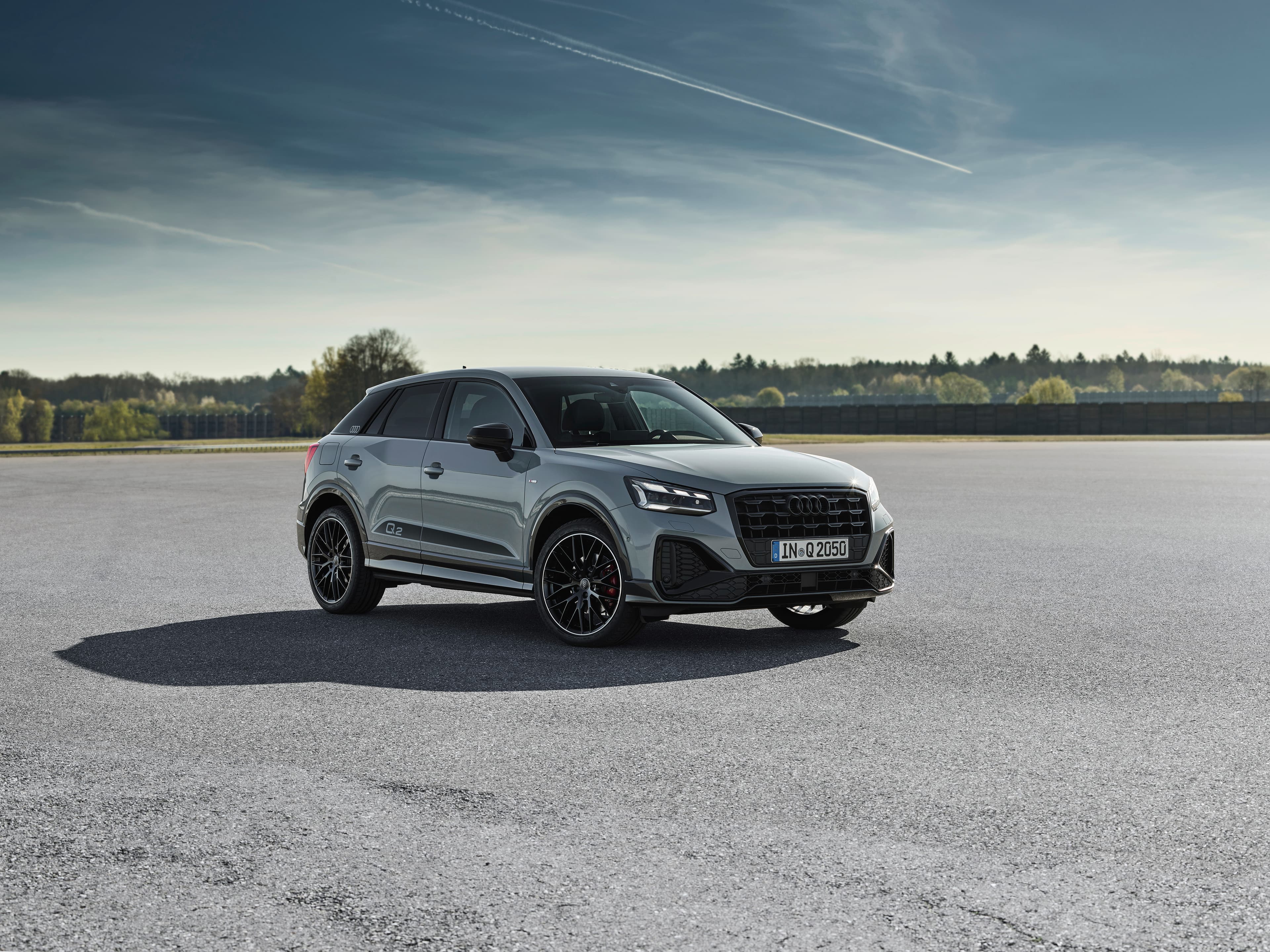 Pilkas Audi Q2 GA, priekinis trijų ketvirčių vaizdas atviroje asfalto aikštelėje